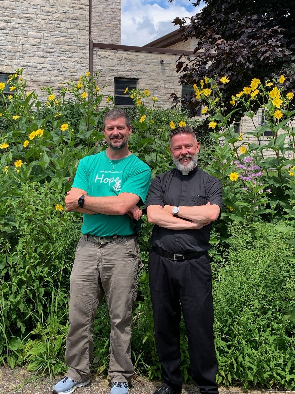 two priests in front of flowers